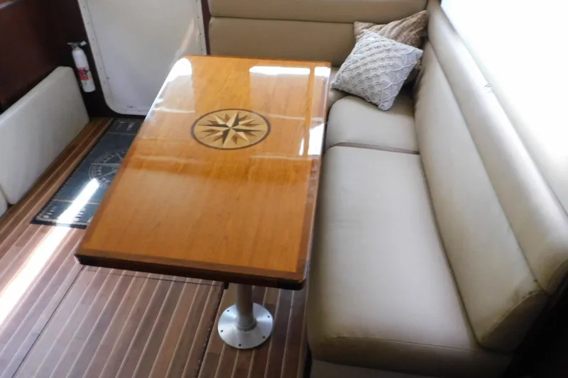 Slide: The Image of Interior of 2000 Camano Troll boat with wooden table and beige seating. - 45