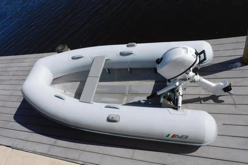 Slide: The Image of Inflatable boat with outboard motor docked on wooden pier. - 46