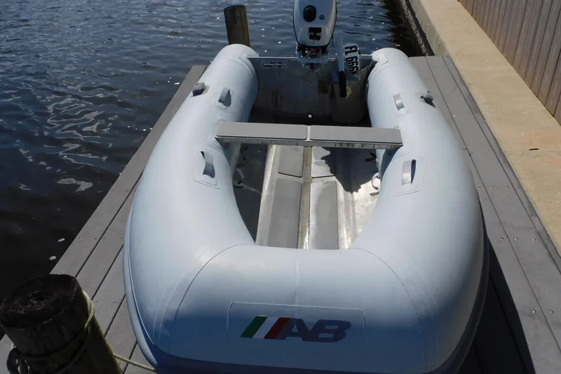 Slide: The Image of Inflatable boat docked by the water, featuring an outboard motor. - 47