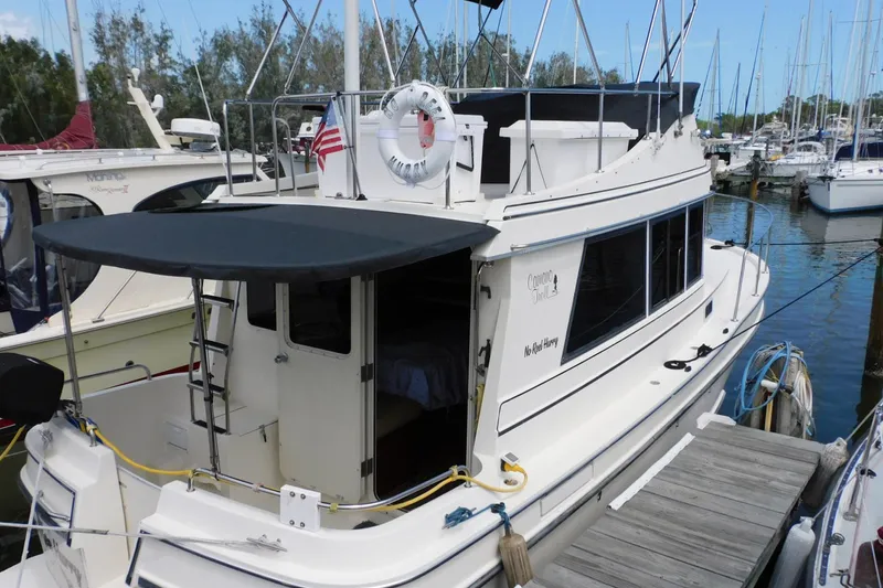 Slide: The Image of 2000 Camano Troll boat docked at marina with canopy and American flag. - 5