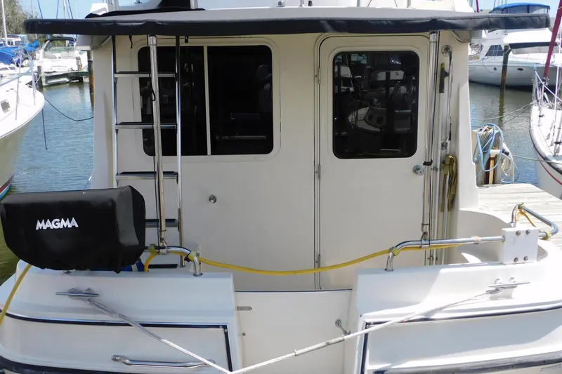 Slide: The Image of 2000 Camano Troll boat stern view with ladder and docked surroundings. - 7