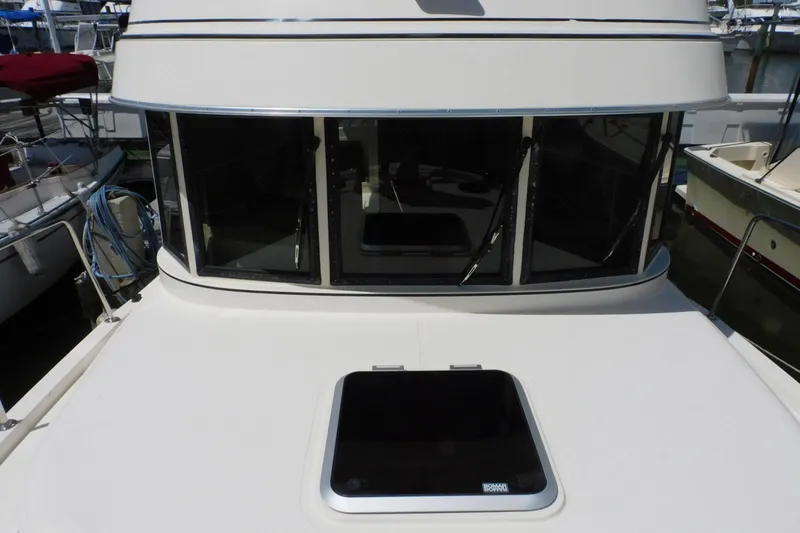 Slide: The Image of 2000 Camano Troll boat front view with windows and hatch in marina. - 8