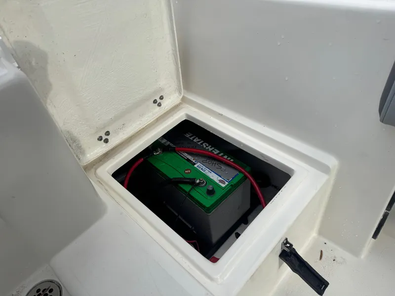 Slide: The Image of Battery compartment of 2025 Defiance Catalina 240 boat, featuring a green battery. - 15