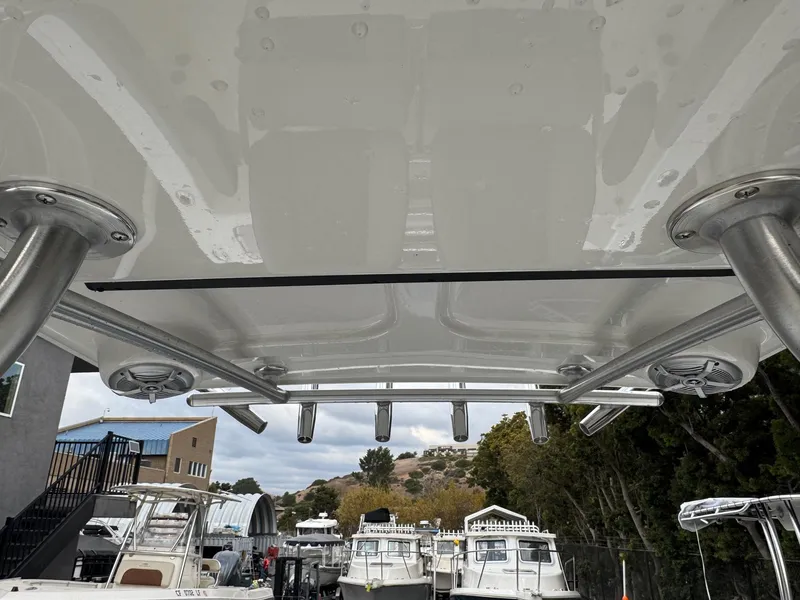 Slide: The Image of 2025 Defiance Catalina 240 boat with rod holders and speakers, docked among other boats. - 23