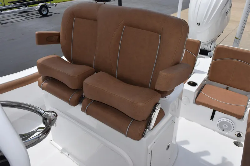 Slide: The Image of 2024 Sea Hunt BX 25 FS boat with brown cushioned seating and steering wheel. - 11