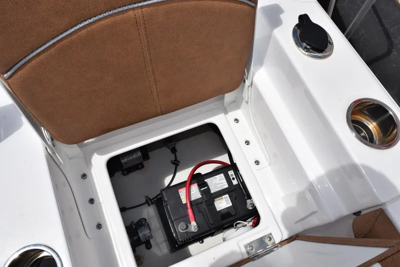 Slide: The Image of 2024 Sea Hunt BX 25 FS boat battery compartment with brown seating and cup holders. - 17