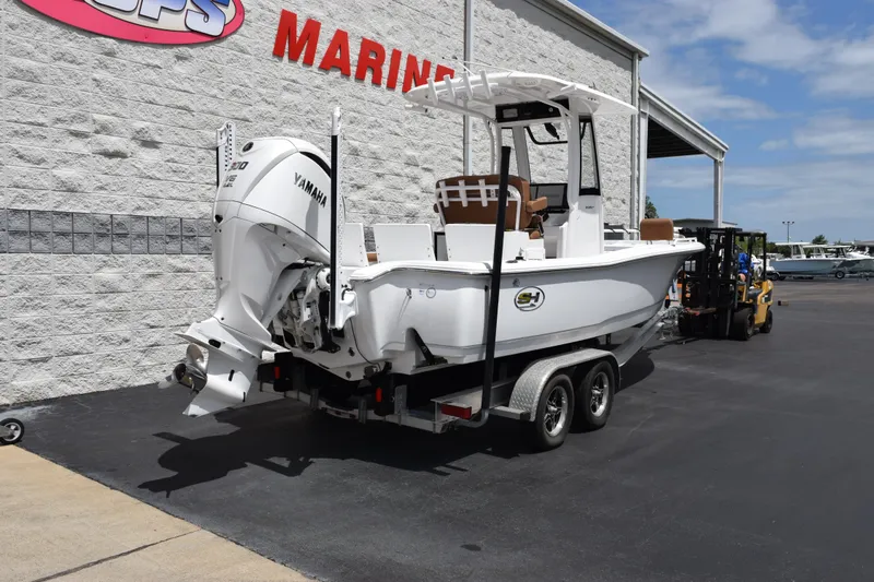 Slide: The Image of 2024 Sea Hunt BX 25 FS boat on trailer, featuring Yamaha engine, parked outside marine store. - 4