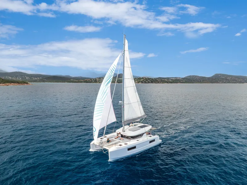 The Image of 2025 Lagoon 38 catamaran sailing on open sea under clear blue sky. - 0