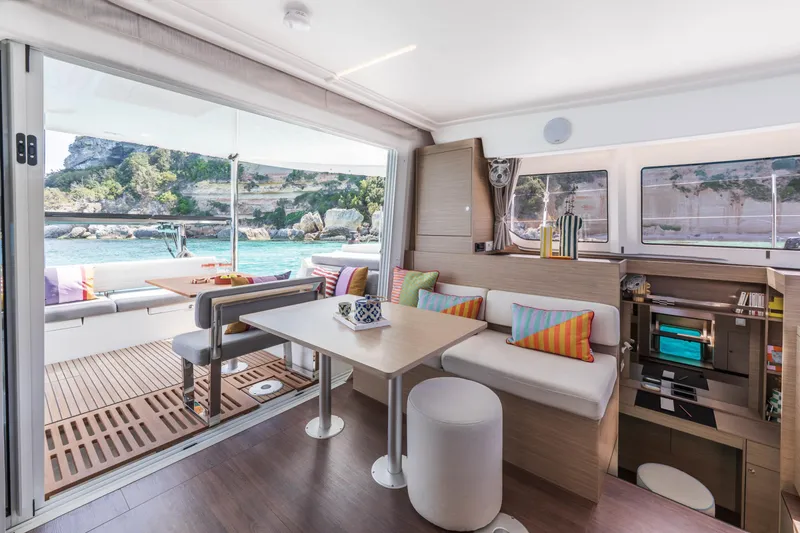 Slide: The Image of Modern interior of 2025 Lagoon 38 catamaran with colorful cushions and scenic ocean view. - 26
