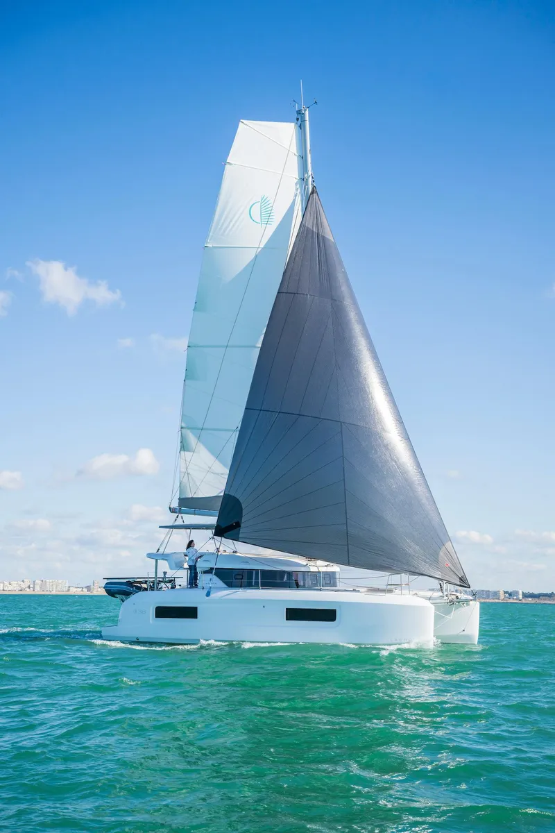 Slide: The Image of 2025 Lagoon 38 catamaran sailing on clear blue waters under a sunny sky. - 82