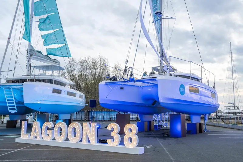 Slide: The Image of 2025 Lagoon 38 catamarans displayed outdoors with illuminated sign. - 84