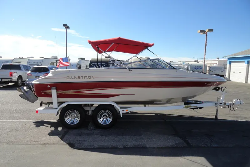 Slide: The Image of 2000 Glastron GX 205 boat with red canopy on trailer in parking lot. - 5