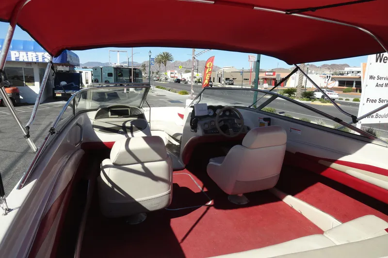 Slide: The Image of Interior view of a 2000 Glastron GX 205 boat with red canopy and seating. - 7