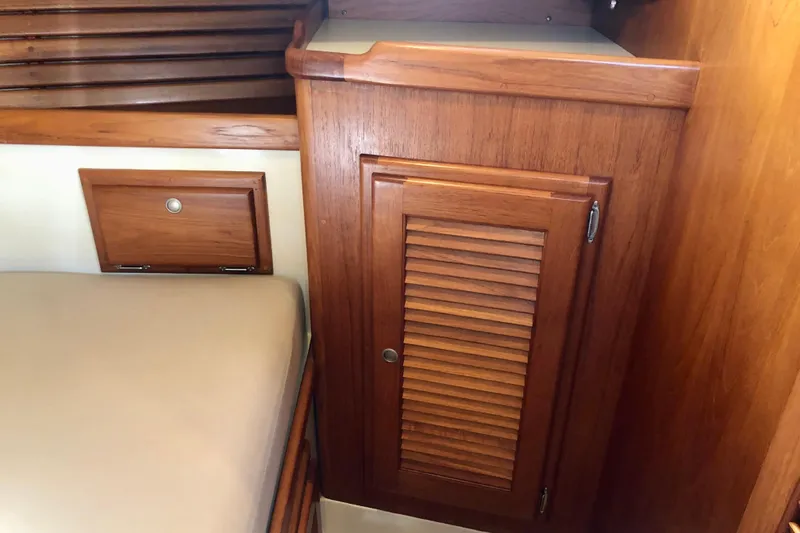 Slide: The Image of Wooden interior of 1998 Pacific Seacraft 40 sailboat, featuring a cabinet and bed. - 16