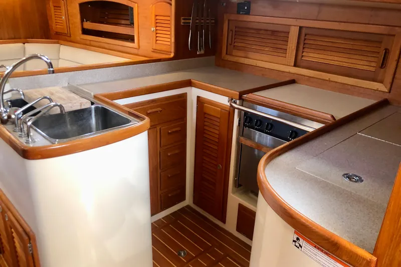 Slide: The Image of Interior of 1998 Pacific Seacraft 40 yacht kitchen with wooden cabinetry and stainless steel sink. - 9