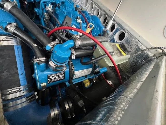 Slide: The Image of Engine compartment of a 2006 Carolina Classic 28FT boat, featuring blue engine components. - 44