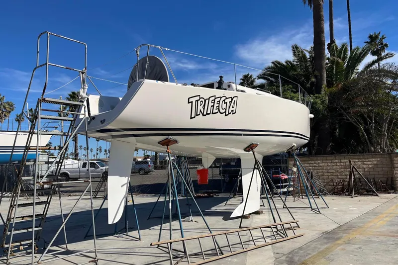 Slide: The Image of 2004 J Boats J/109 sailboat "Trifecta" on stands, in a sunny marina setting. - 3