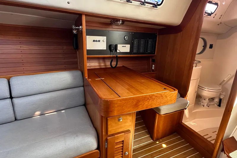 Slide: The Image of Interior of 2004 J Boats J/109 sailboat with wooden table, seating, and navigation equipment. - 47
