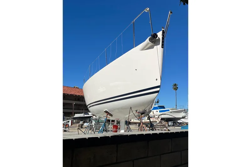 Slide: The Image of 2004 J Boats J/109 sailboat on stands, viewed from the bow, under clear blue sky. - 6