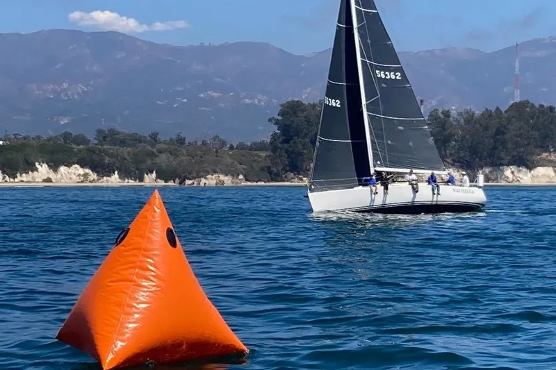 Slide: The Image of Sailboat J/109 from 2004 near an orange buoy on a clear day. - 9