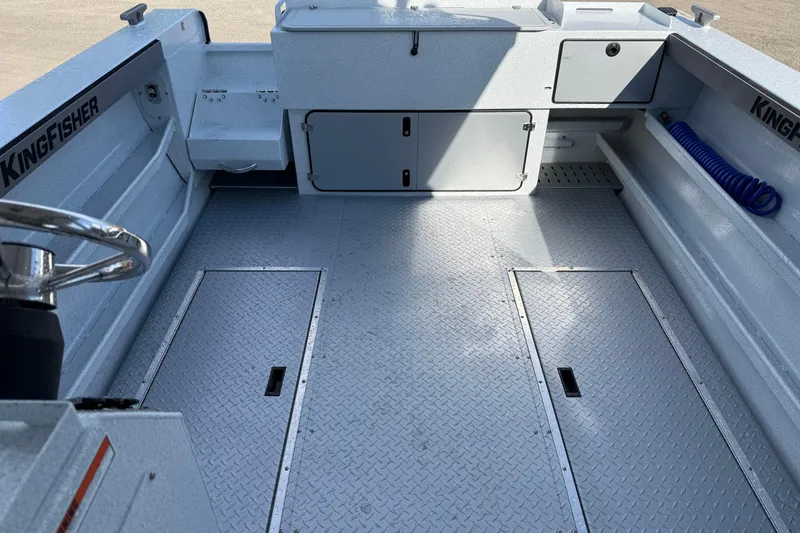 Slide: The Image of 2026 KingFisher 2425 Escape HT boat interior with storage compartments and steering wheel. - 26