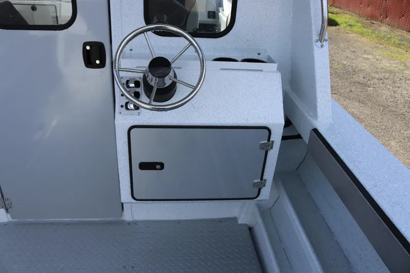 Slide: The Image of Interior of 2026 KingFisher 2425 Escape HT boat, featuring steering wheel and storage compartment. - 27