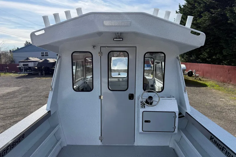 Slide: The Image of 2026 KingFisher 2425 Escape HT boat, showcasing helm and cabin exterior in a marina setting. - 4