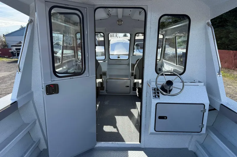Slide: The Image of Interior view of 2026 KingFisher 2425 Escape HT boat, showcasing helm and seating area. - 5