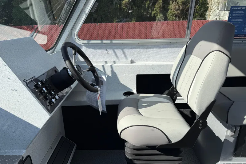 Slide: The Image of Interior of 2026 KingFisher 2425 Escape HT boat, featuring steering wheel and captain's chair. - 8