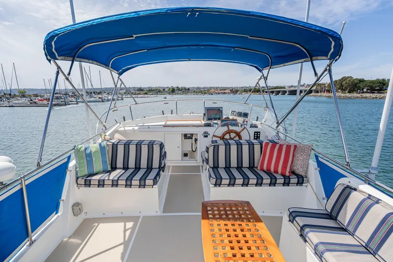 Slide: The Image of Flybridge of 1987 Grand Banks 46 Classic yacht with striped seating and blue canopy. - 14