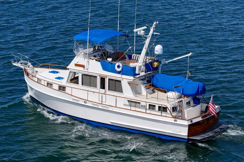 Slide: The Image of 1987 Grand Banks 46 Classic yacht cruising on open water with blue canopy. - 7