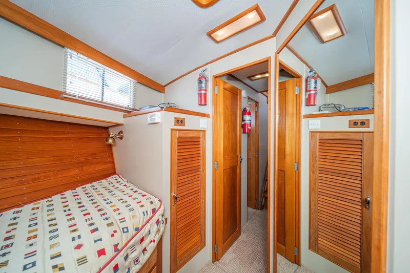 Slide: The Image of 1987 Grand Banks 46 Classic cabin interior with wooden finishes and nautical bedding. - 72