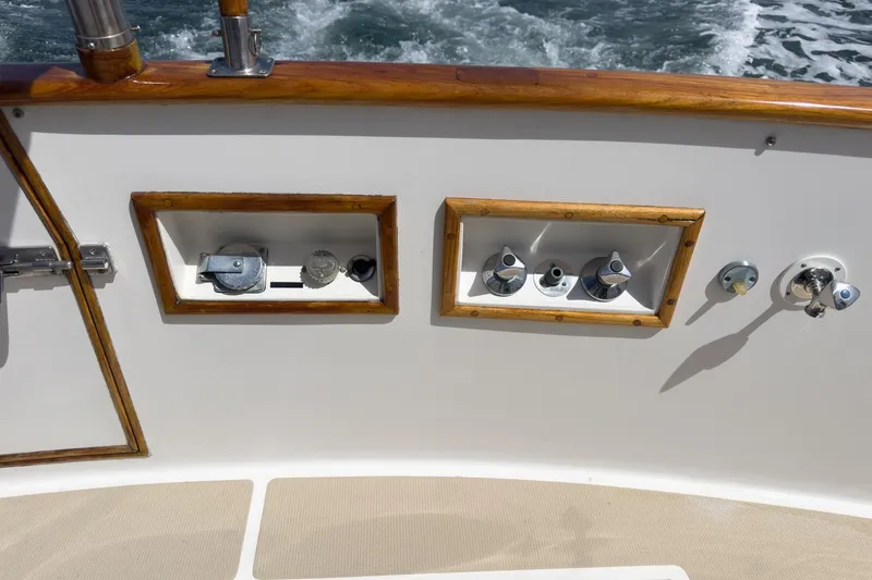 Slide: The Image of 1987 Grand Banks 46 Classic yacht controls with wooden trim, ocean in background. - 77