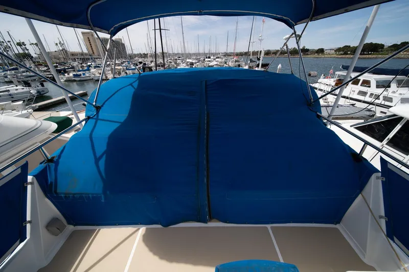 Slide: The Image of 1987 Grand Banks 46 Classic yacht with blue cover at marina. - 80