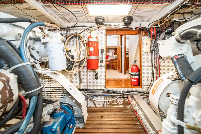 Slide: The Image of Engine room of a 1987 Grand Banks 46 Classic yacht, featuring equipment and fire extinguishers. - 88