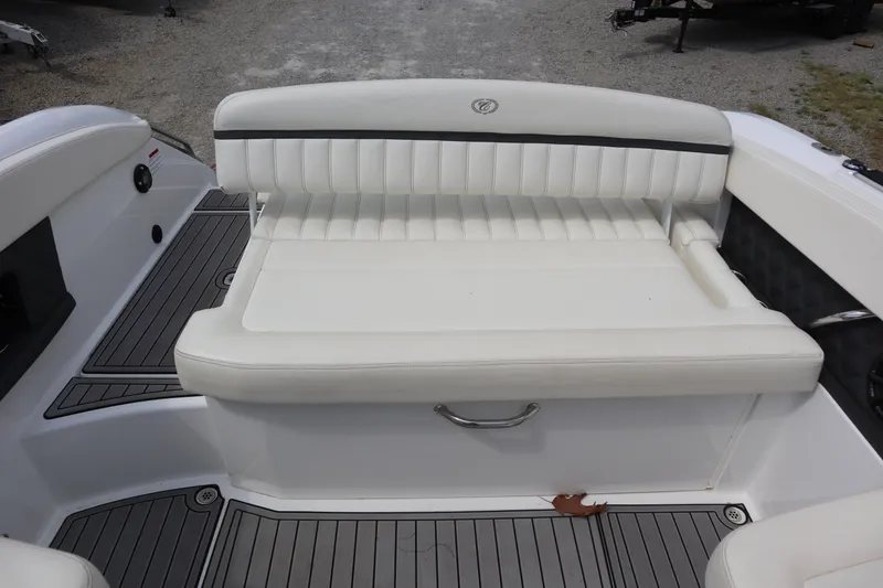 Slide: The Image of 2012 Cobalt A25 boat interior with white cushioned seating and gray flooring. - 22