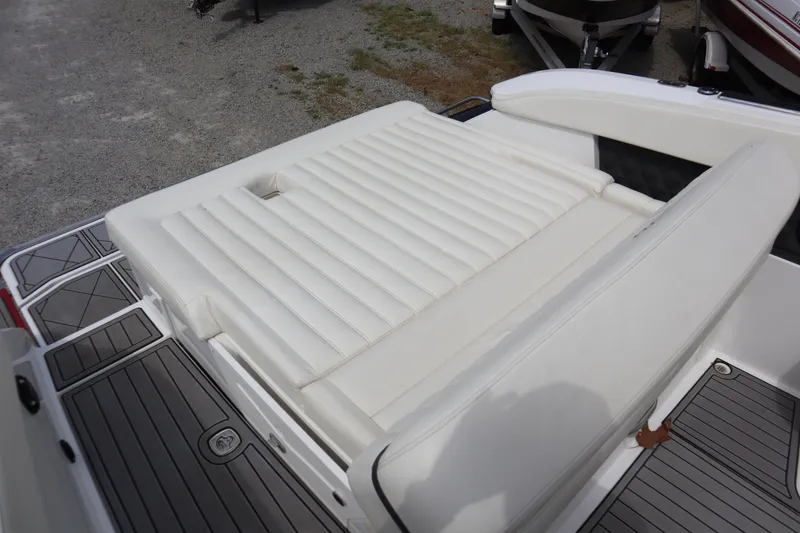 Slide: The Image of 2012 Cobalt A25 boat with white cushioned seating and gray deck flooring. - 23