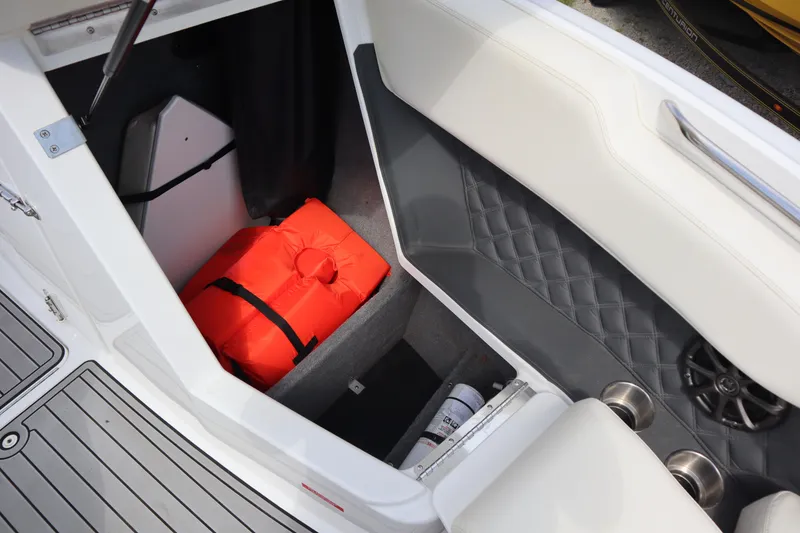 Slide: The Image of Interior storage of 2012 Cobalt A25 boat with orange life jacket and speaker. - 4