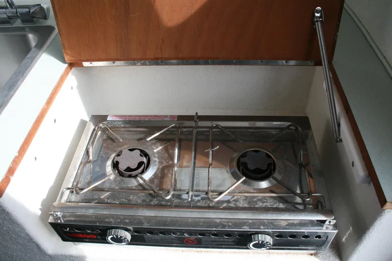 Slide: The Image of 2003 SeaSport Explorer 2400 boat stove with two burners in a compact kitchen area. - 11