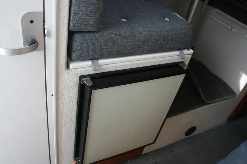 Slide: The Image of Interior of a 2003 SeaSport Explorer 2400 boat, featuring a compact seating area. - 13