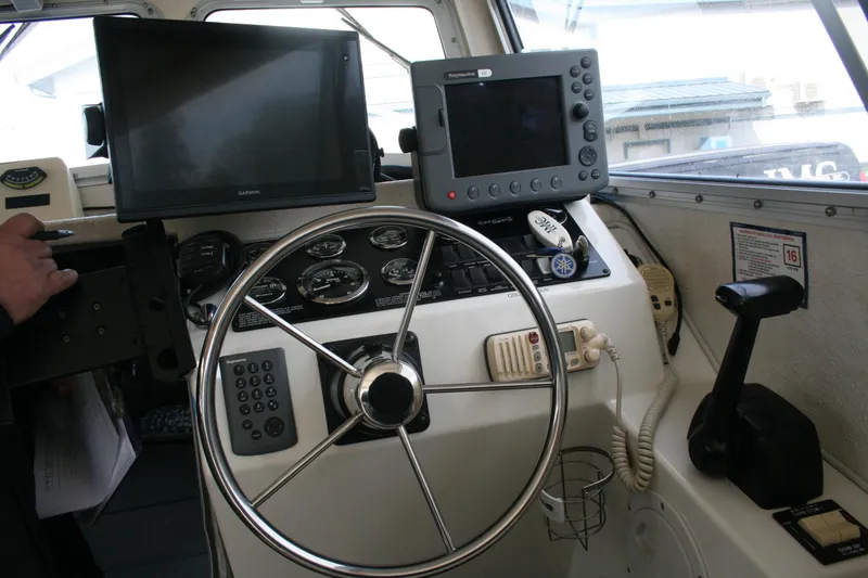 Slide: The Image of 2003 SeaSport Explorer 2400 helm with navigation equipment and steering wheel. - 6