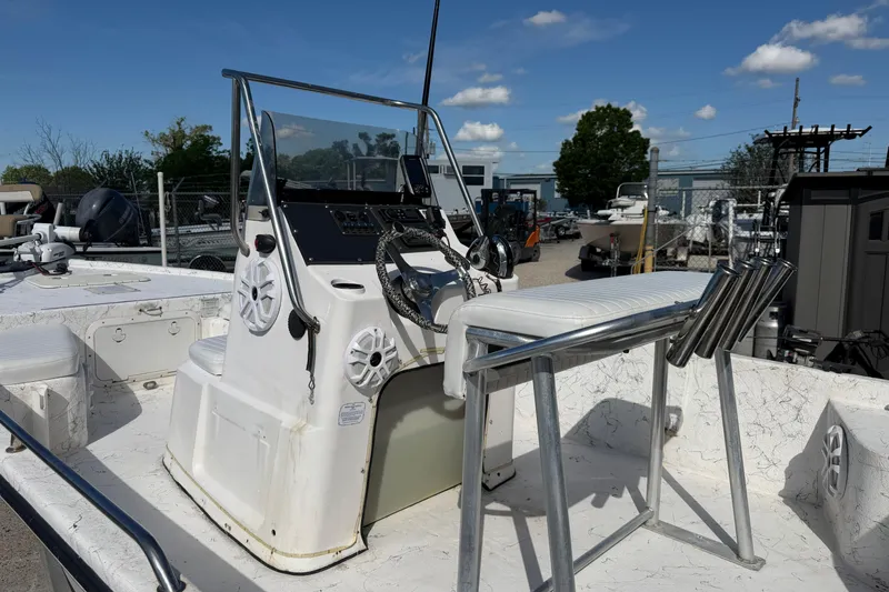 Slide: The Image of Kenner 1800 VISION 2004 boat with steering console and seating, under clear blue sky. - 14