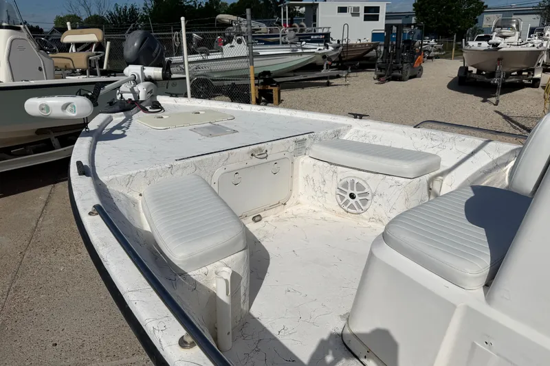 Slide: The Image of 2004 Kenner 1800 VISION boat with white seating and deck, parked in a marina. - 15