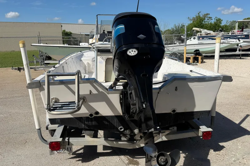 Slide: The Image of 2004 Kenner 1800 VISION boat with outboard motor on trailer in a parking lot. - 5
