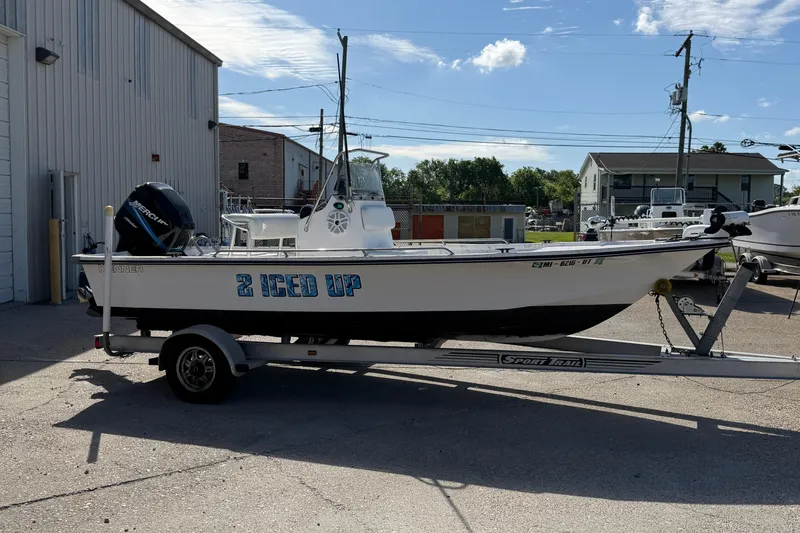 Slide: The Image of 2004 Kenner 1800 VISION boat on trailer, labeled "2 ICED UP," parked outdoors. - 8