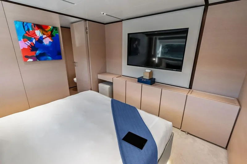 Slide: The Image of Luxurious bedroom interior on Custom Line Navetta 33 yacht, featuring modern decor and vibrant artwork. - 81