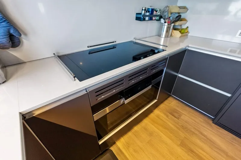 Slide: The Image of Modern kitchen on Custom Line Navetta 33 yacht, featuring sleek countertops and induction cooktop. - 70