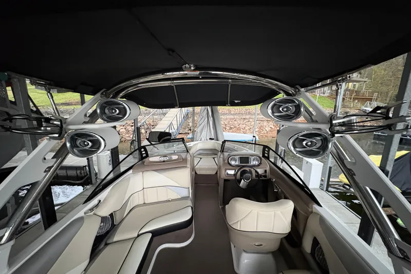 Slide: The Image of 2011 Malibu Wakesetter 247 LSV interior with speakers and seating, docked at a marina. - 10