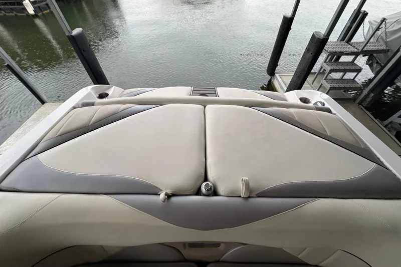 Slide: The Image of 2011 Malibu Wakesetter 247 LSV boat interior with cushioned seating near water. - 14