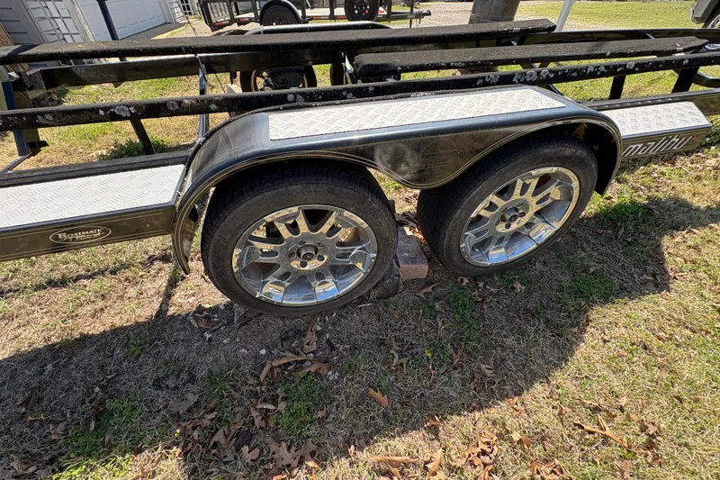 Slide: The Image of Trailer for 2011 Malibu Wakesetter 247 LSV with chrome wheels on grass. - 21